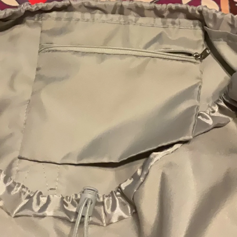 Large gray laundry bag with handle and backpack straps. Front and inside pockets